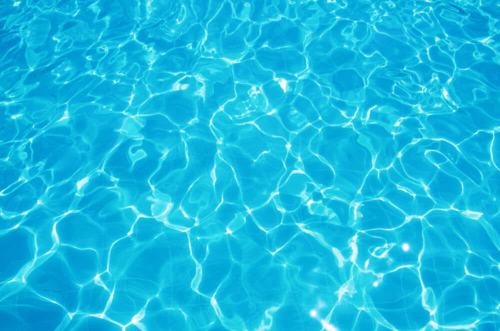 Bright blue pool water with rippling patterns and reflections of sunlight. - Home Instead
