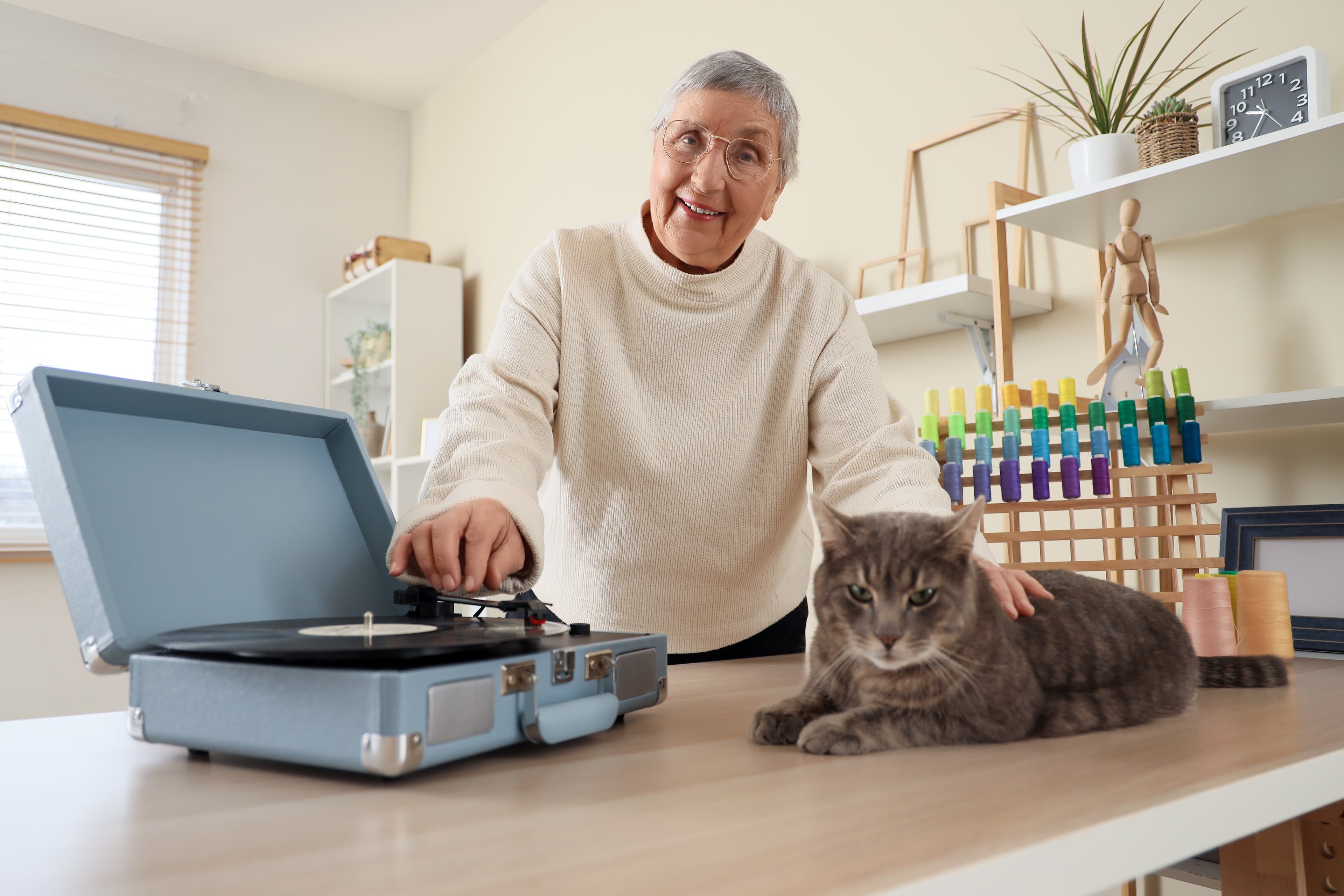 Senior lady enjoying music on her record player somehting recommended by outstanding rated care company Home Instead Stourbridge Hagley and Halesowen