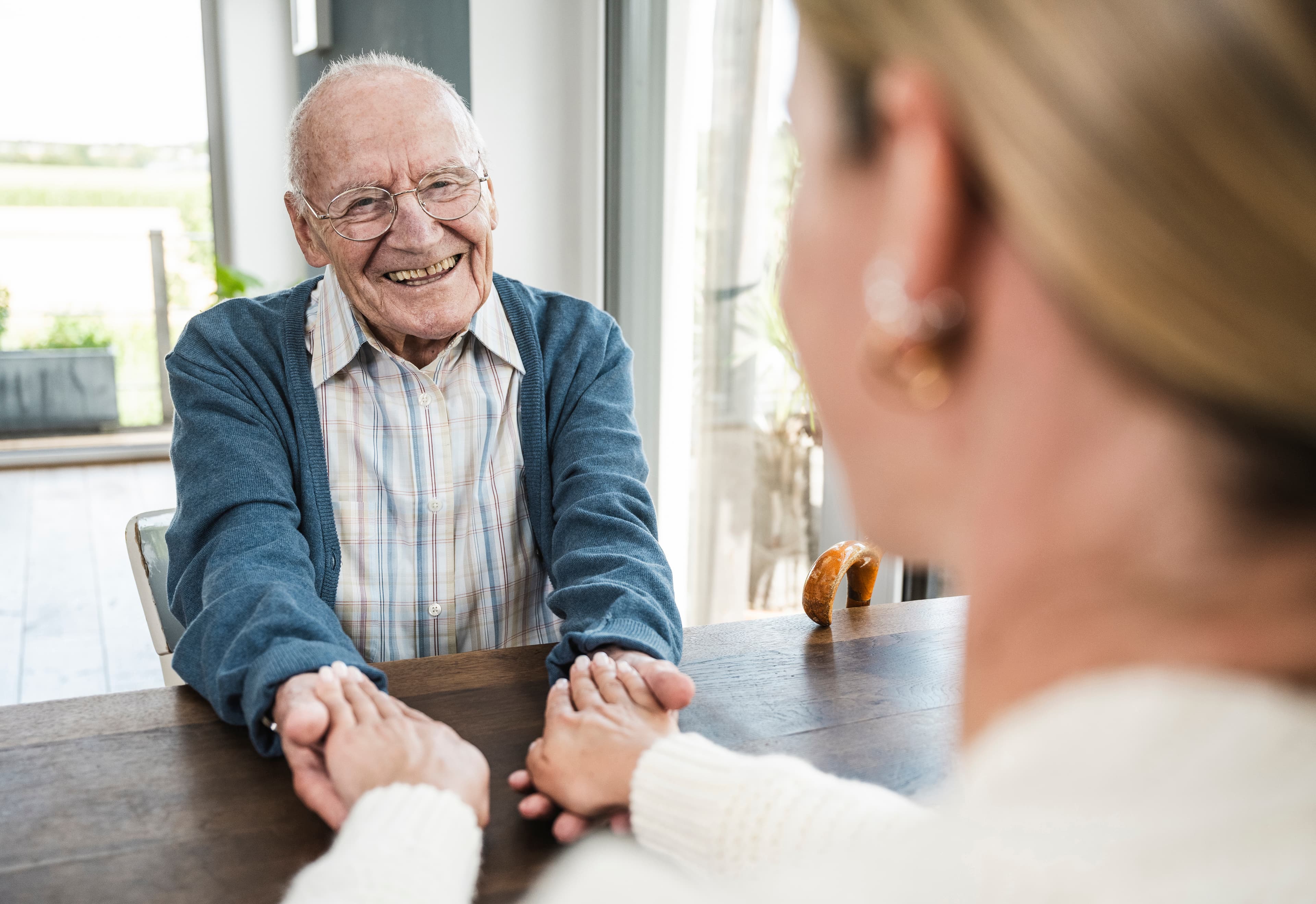 Happy senior man holding hands with daughter - Home Instead