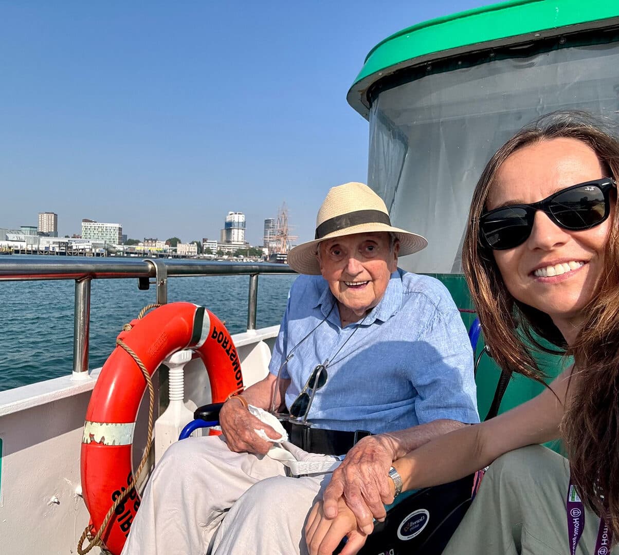 Elderly man in his wheelchair with his female carer on a boat trip