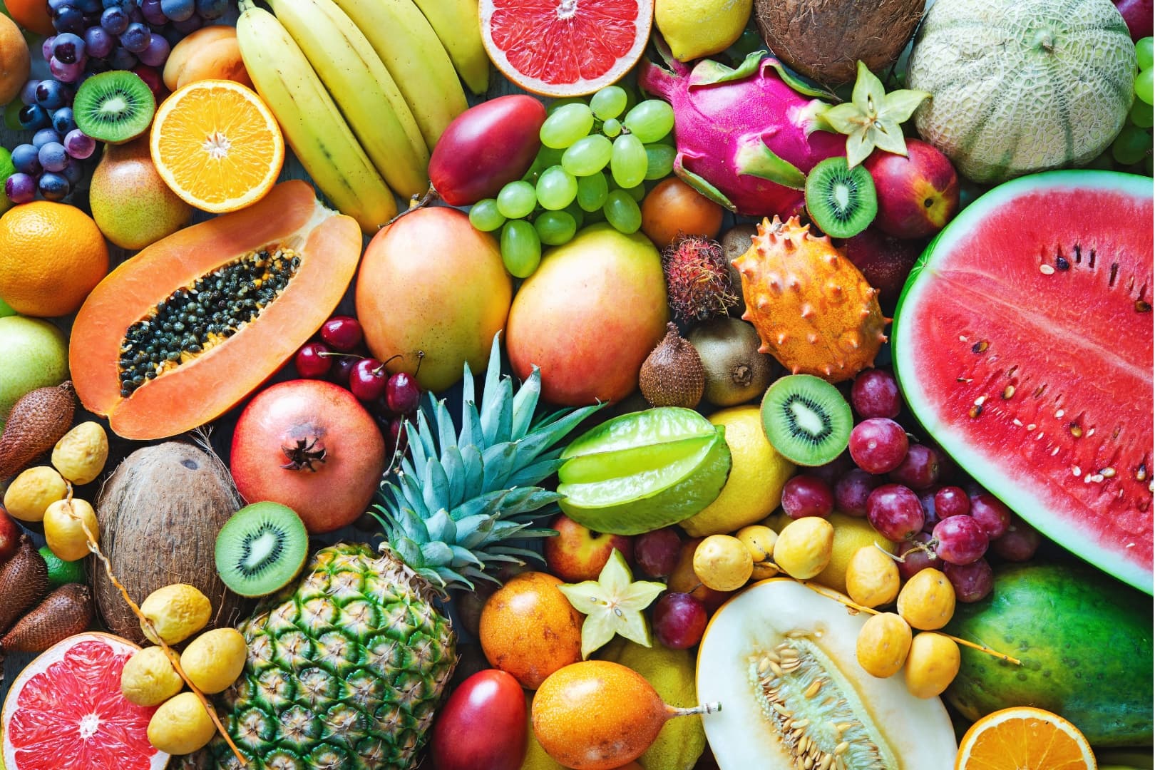 A colorful assortment of various fruits, including watermelon, papaya, bananas, and pineapples. - Home Instead