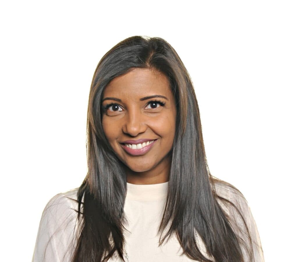 Leena with long black hair smiling beautifully