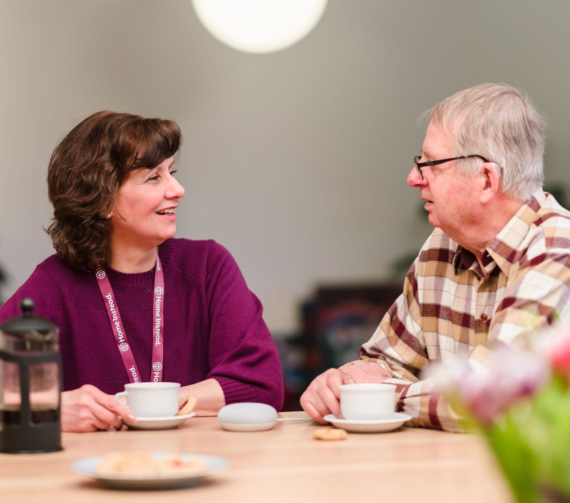 Home Instead live-in carer drinking coffee with her client