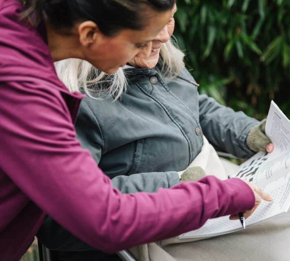Older woman with female carer doing puzzles together