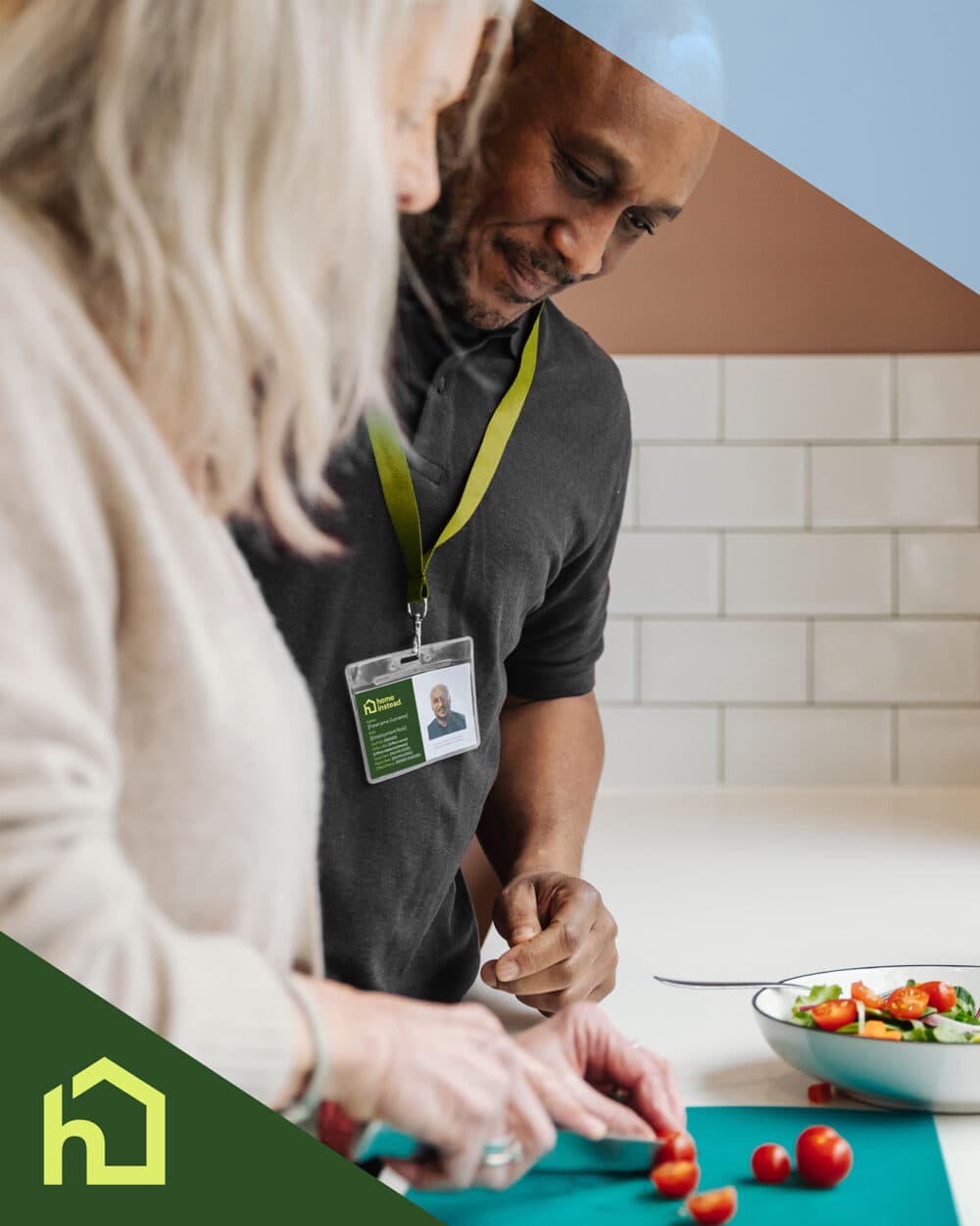 A man and woman slice cherry tomatoes together in a kitchen, with a salad bowl on the counter. - Home Instead