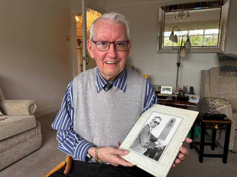 older gentleman David Mitchell holding picture of man in front on Branwyn Hall clock