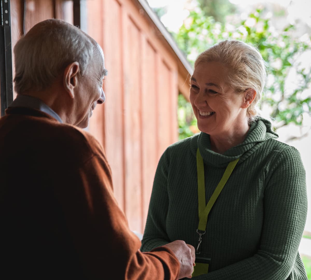 Two people happy and smiling while shaking hands at the door