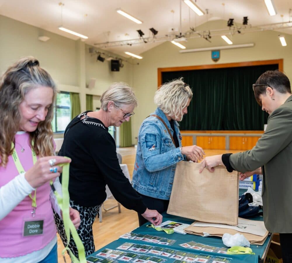 Woman holding a green lanyard and other people looking at IDs