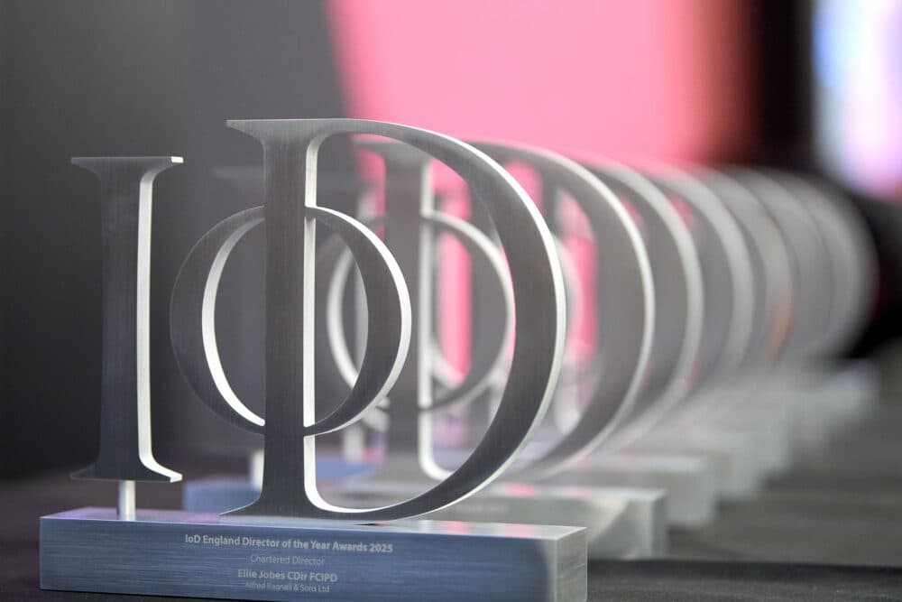 A row of silver IoD Director of the Year Award trophies displayed on a table. - Home Instead