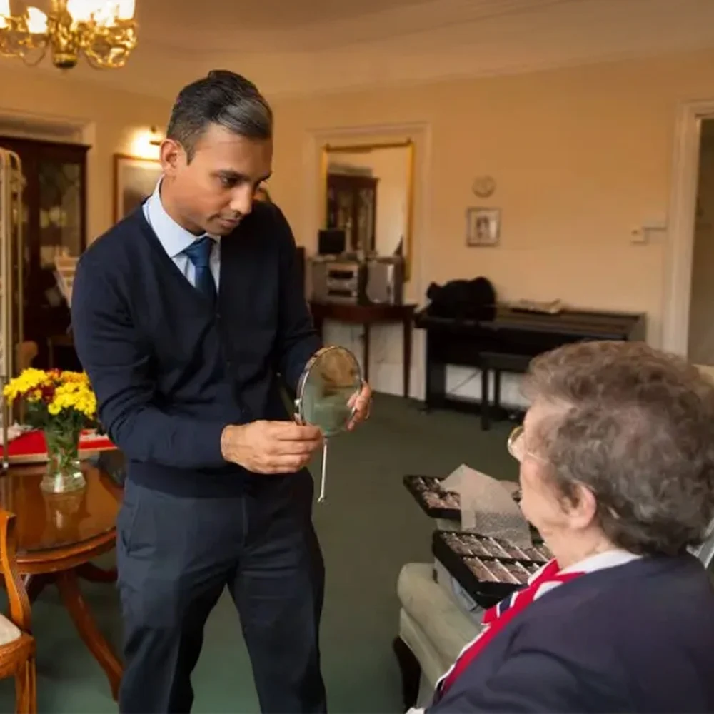 Opticall In Home Eye Care Optometrist holding a mirror in front of his client