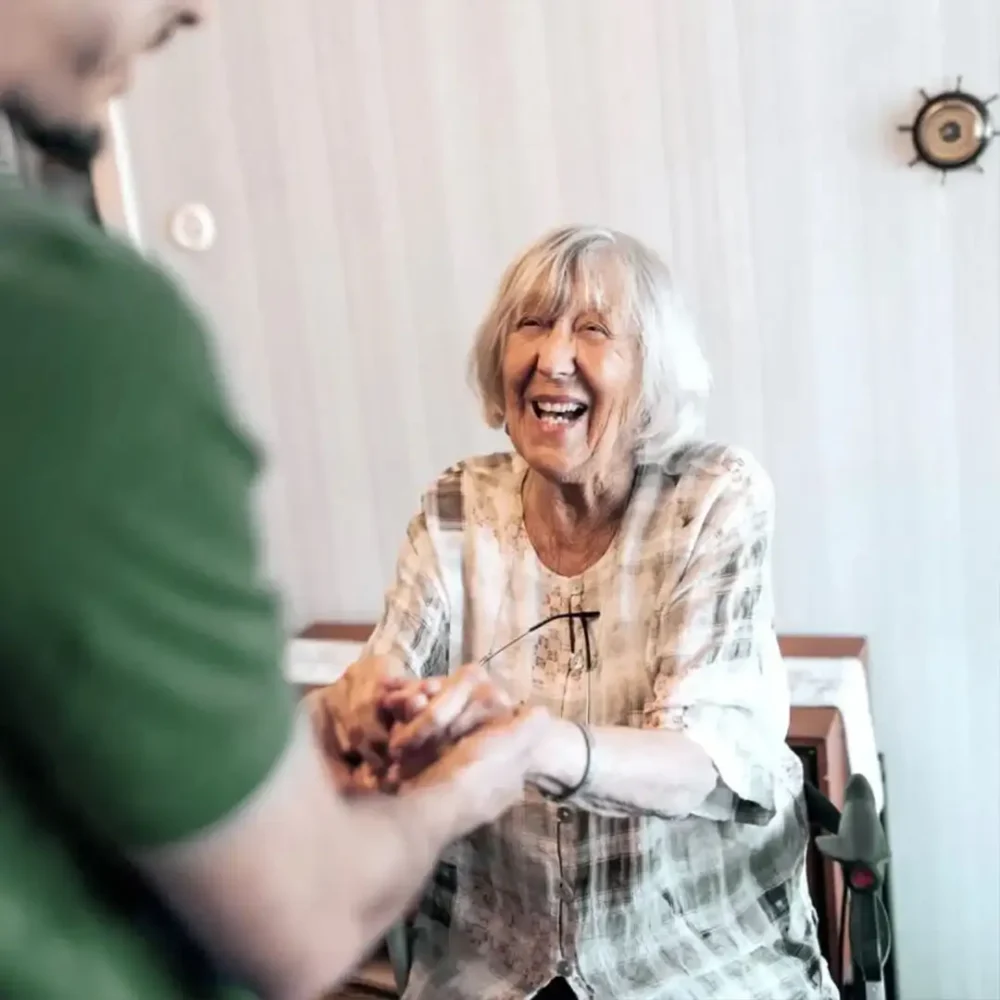 Happy older lady being helped up by her Home Instead care professional