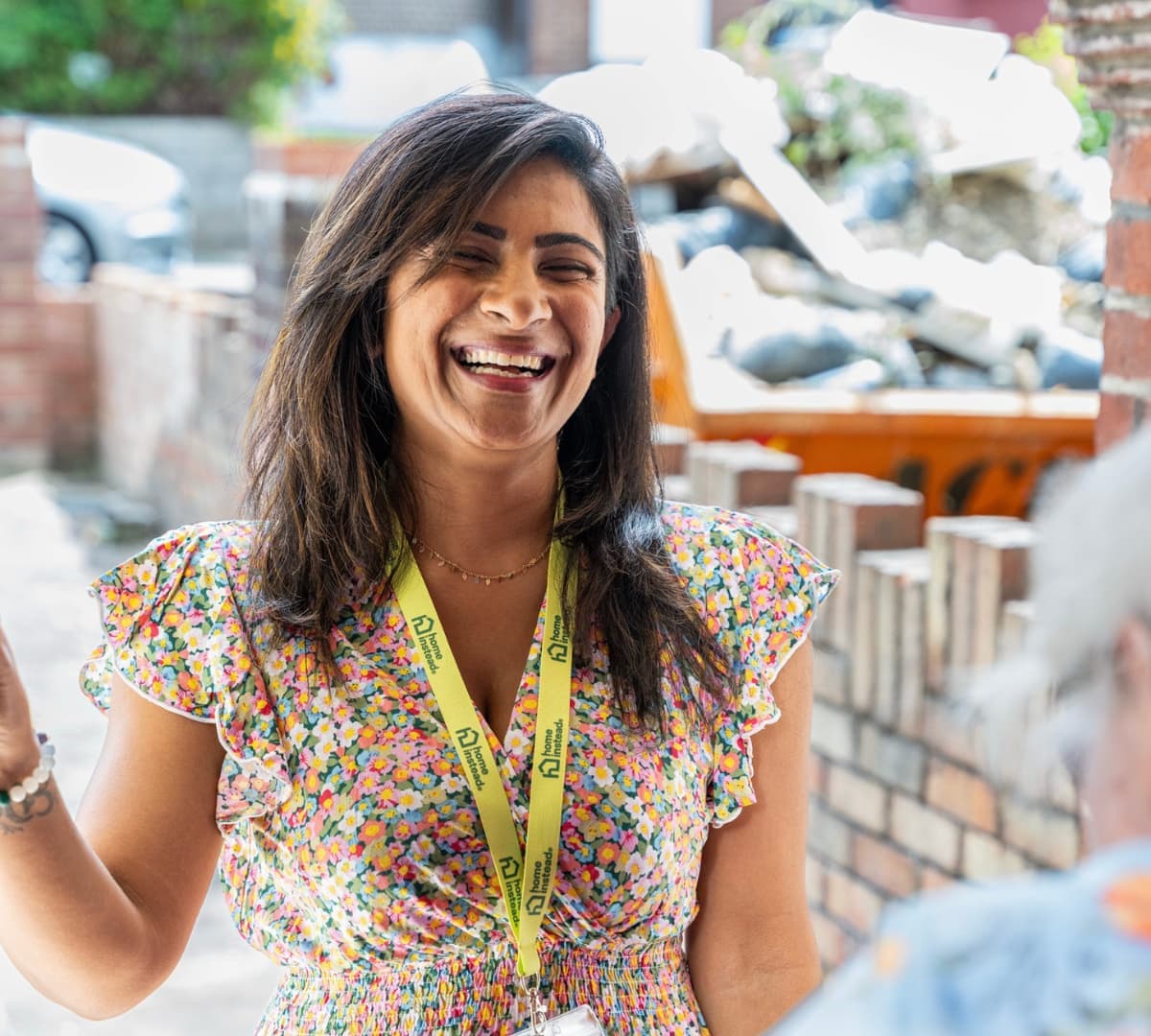 A woman with long hair happy and smiling while standing at the door