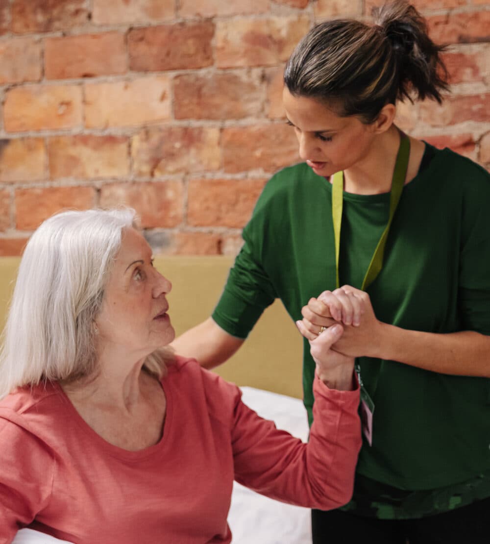 A Care Professional Helps to Steady an Older Lady