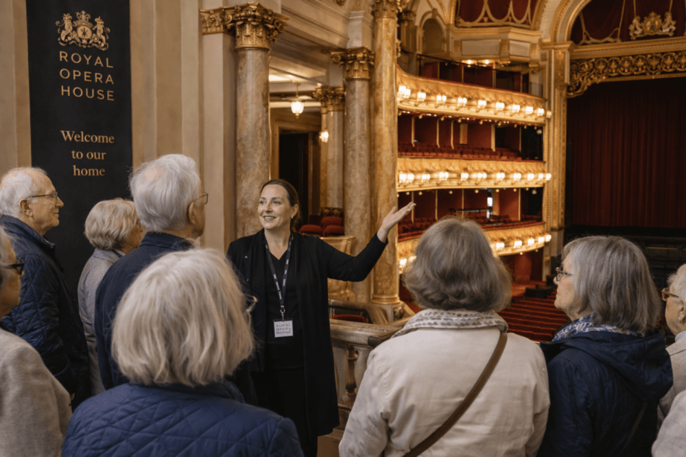 A guide leads a group of pensioners on a tour inside the ornate Royal Opera House auditorium. - Home Instead