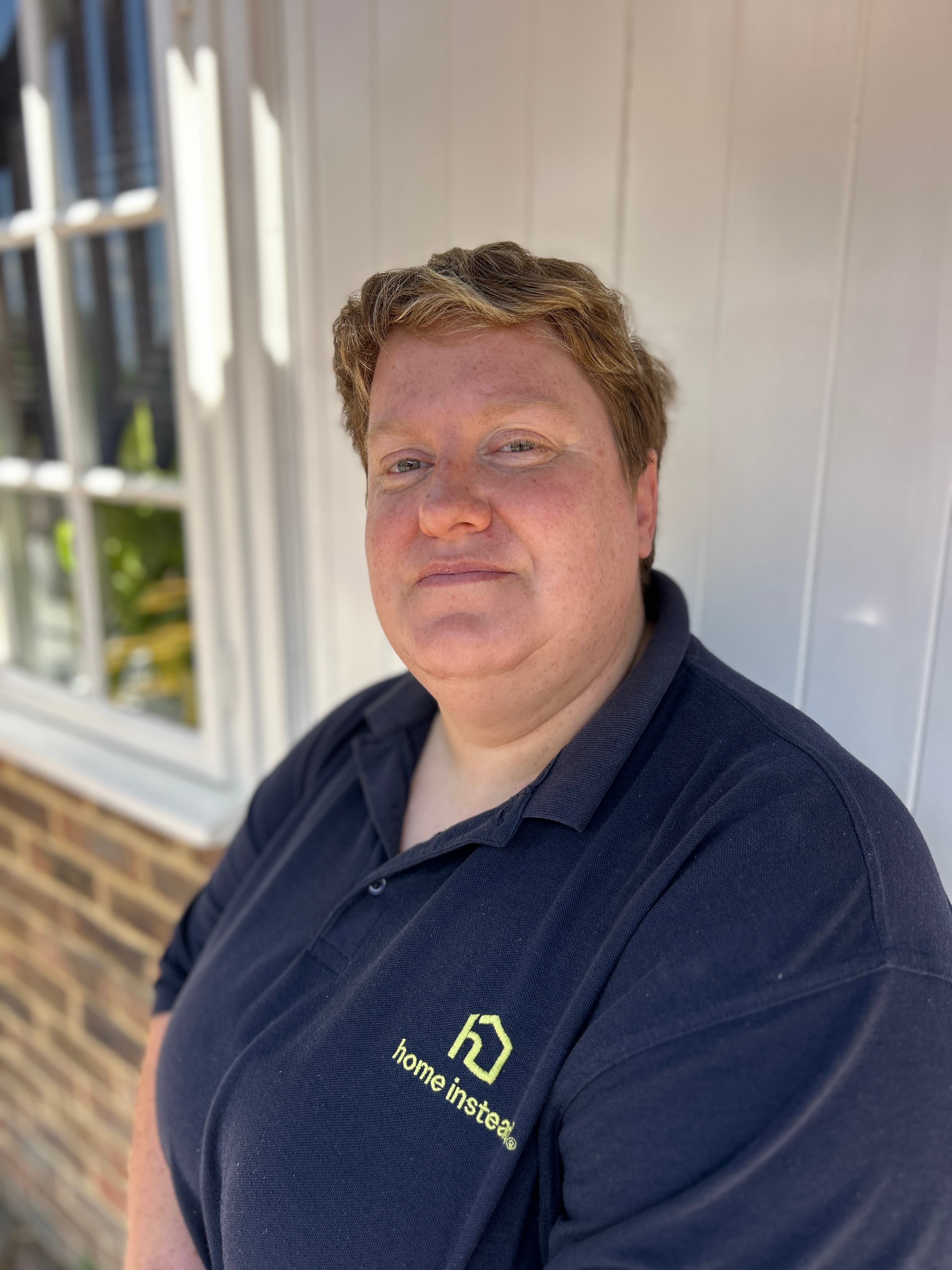 Natalie, Field Supervisor at Home Instead Lewes District and Uckfield, wearing a navy Home Instead polo shirt and smiling at the camera.